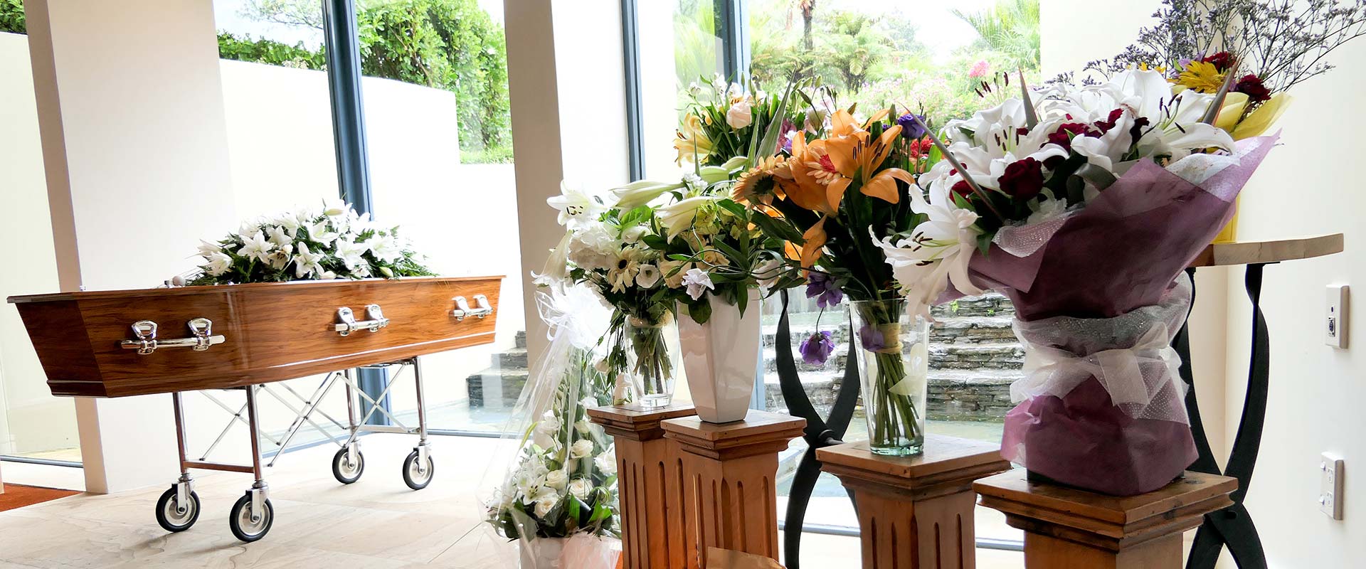 Ataúd en un servicio funeral o cementerio con variedad de arreglos florales 